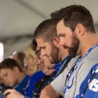 Guests looking at programs at the Jamie Hosford Football Center dedication.